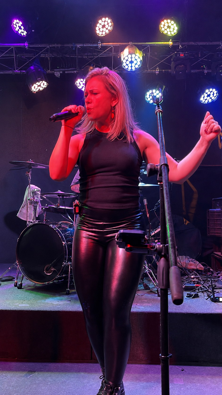 Christa singing under red stage lights